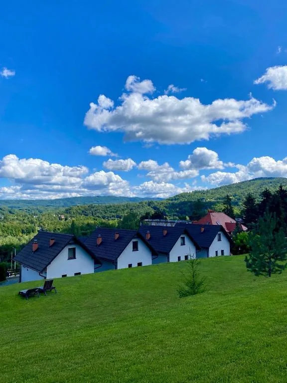 Domki i trawiasty stok pod letnim niebem